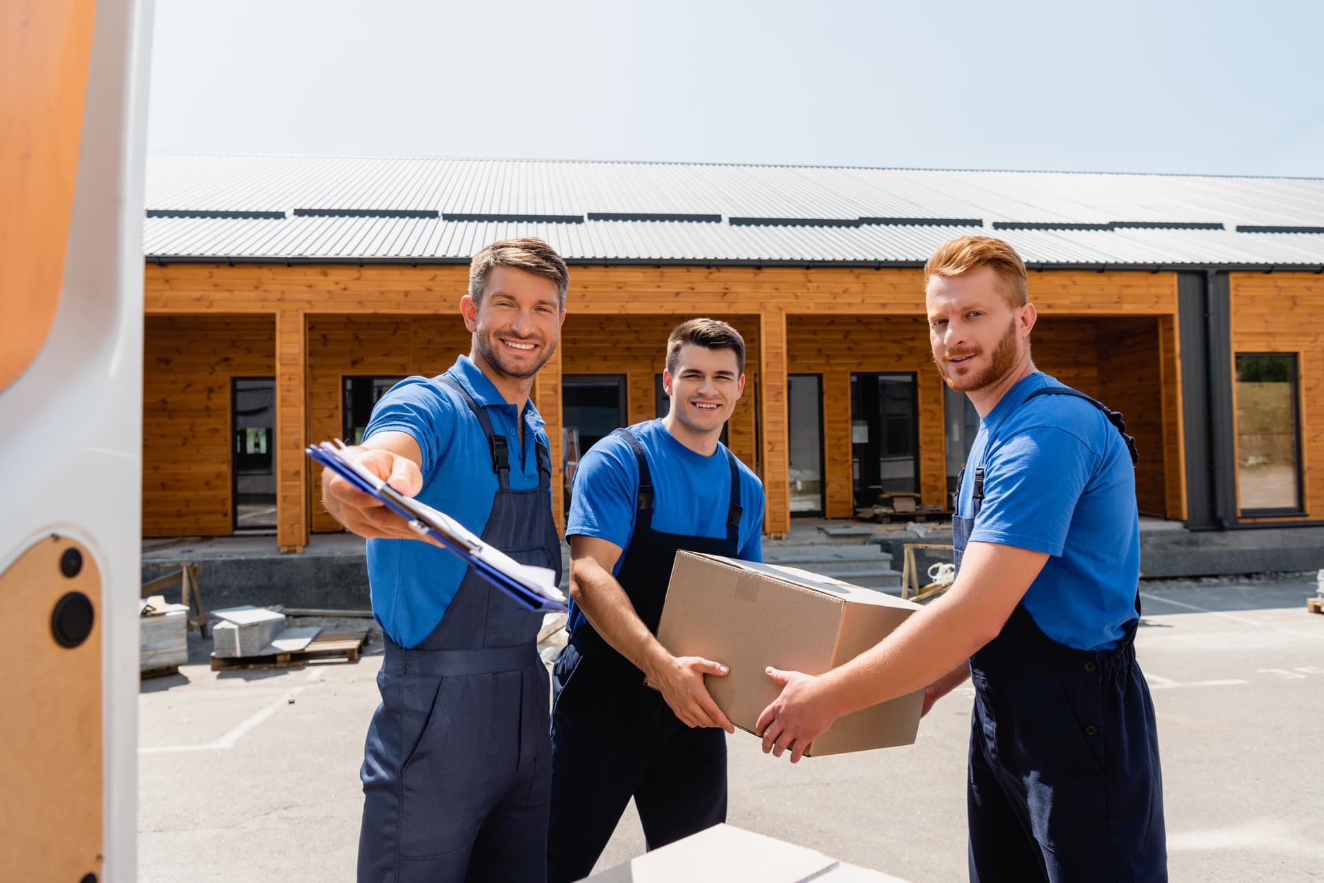 A mover reviewing a moving checklist with a clipboard before loading the truck