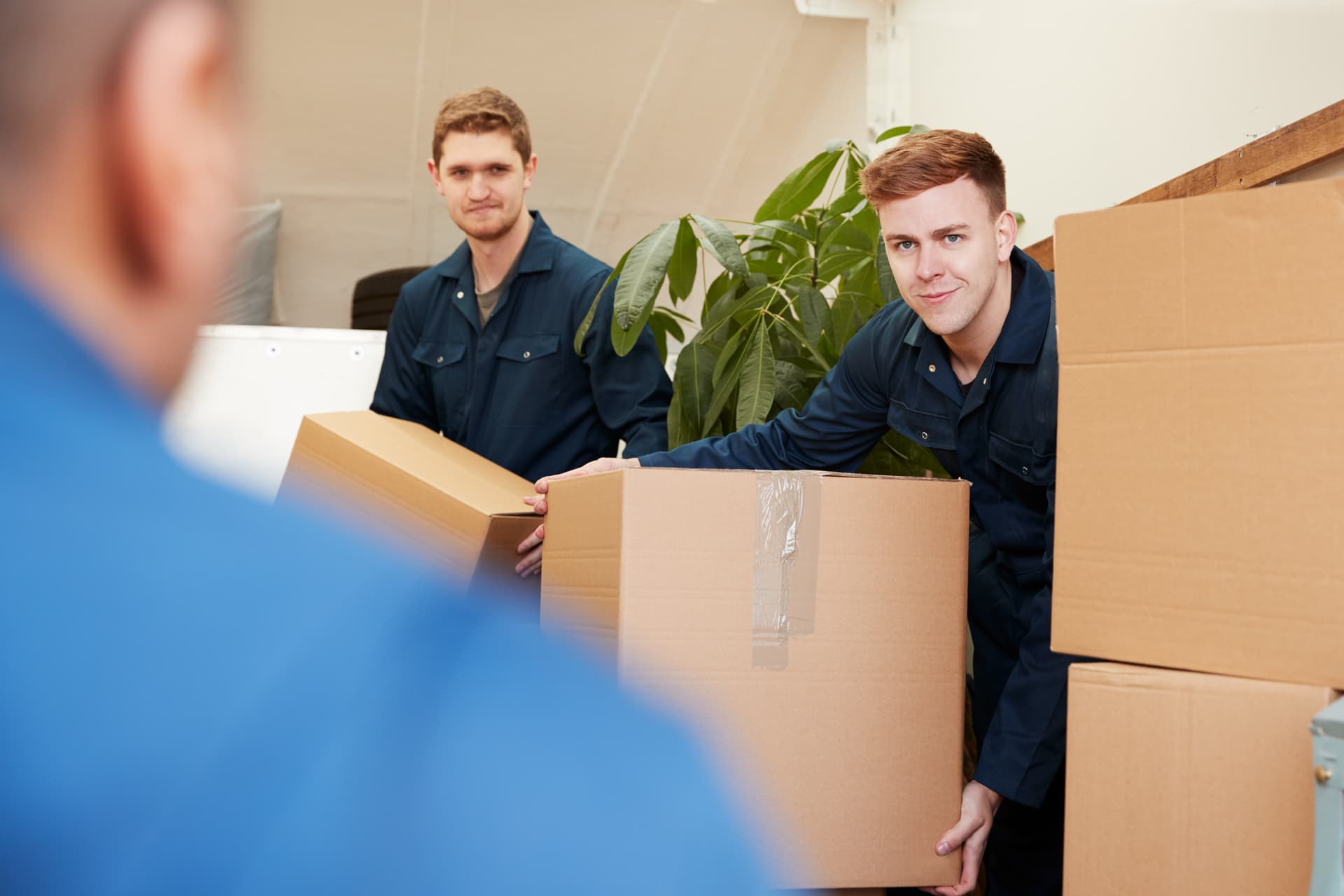 Removal company workers unloading furniture and boxes from a moving truck in St. Petersburg