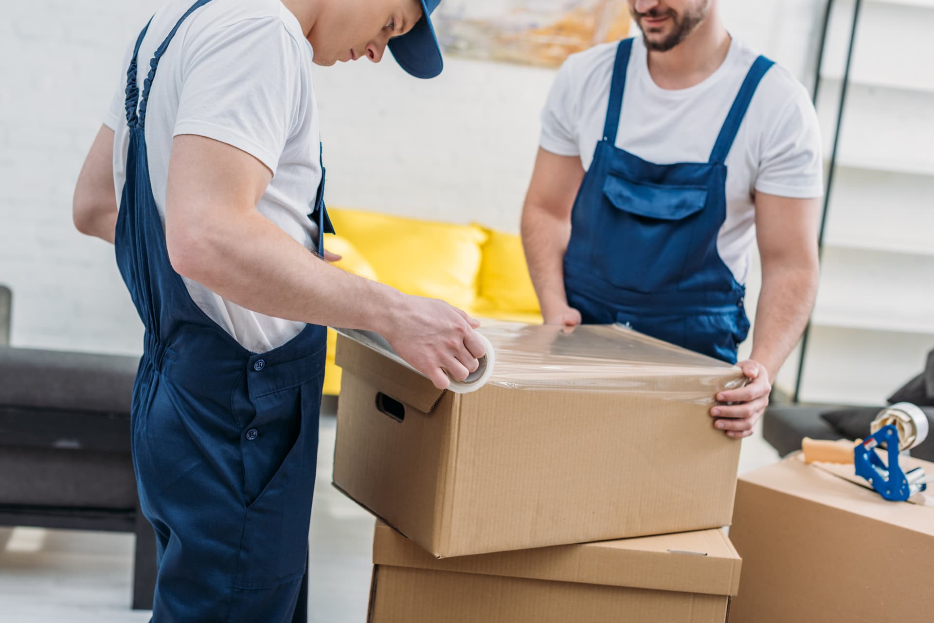 Movers carefully wrapping and packing cardboard boxes for a Florida move