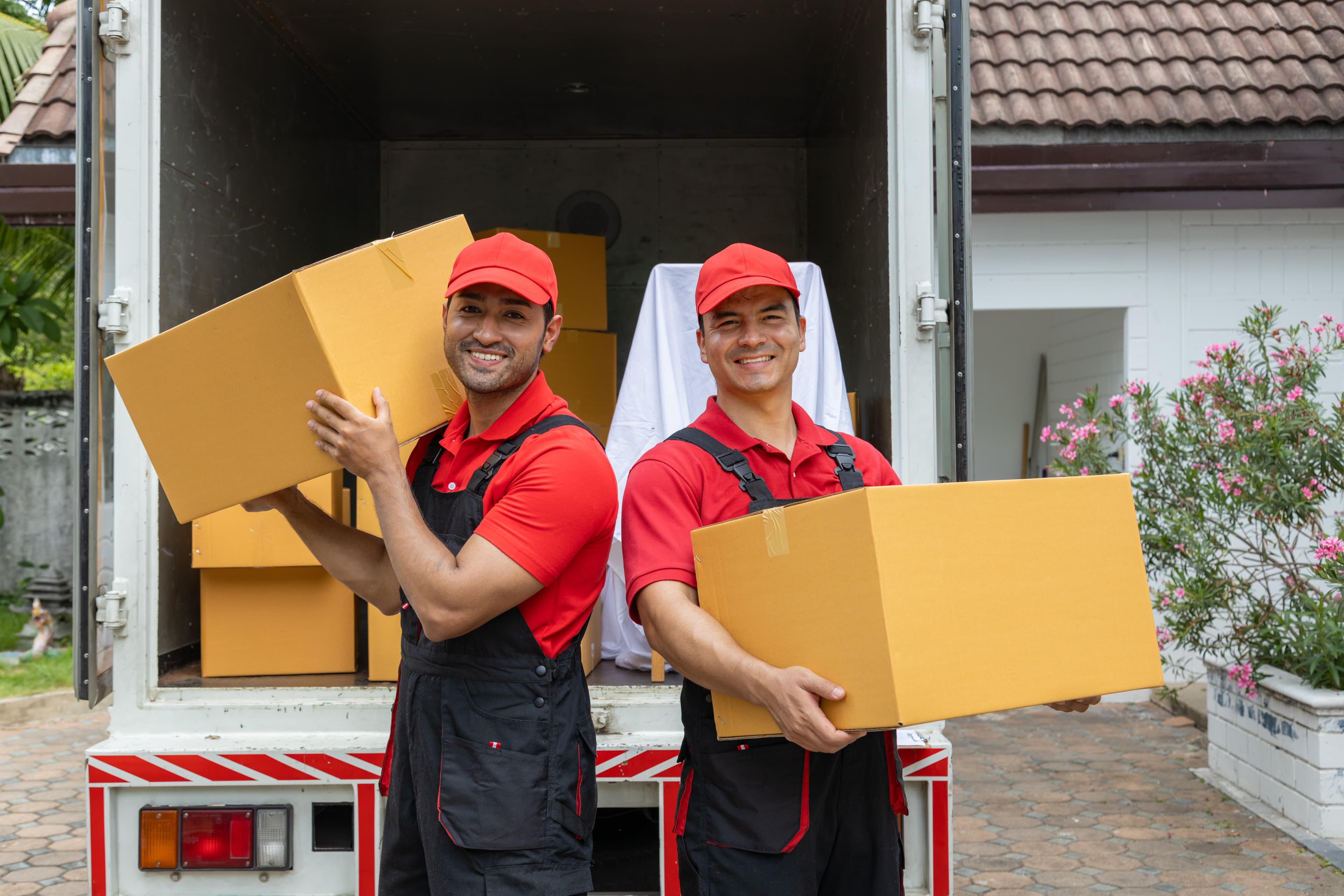 Two movers unloading boxes and furniture during local move in St. Petersburg FL