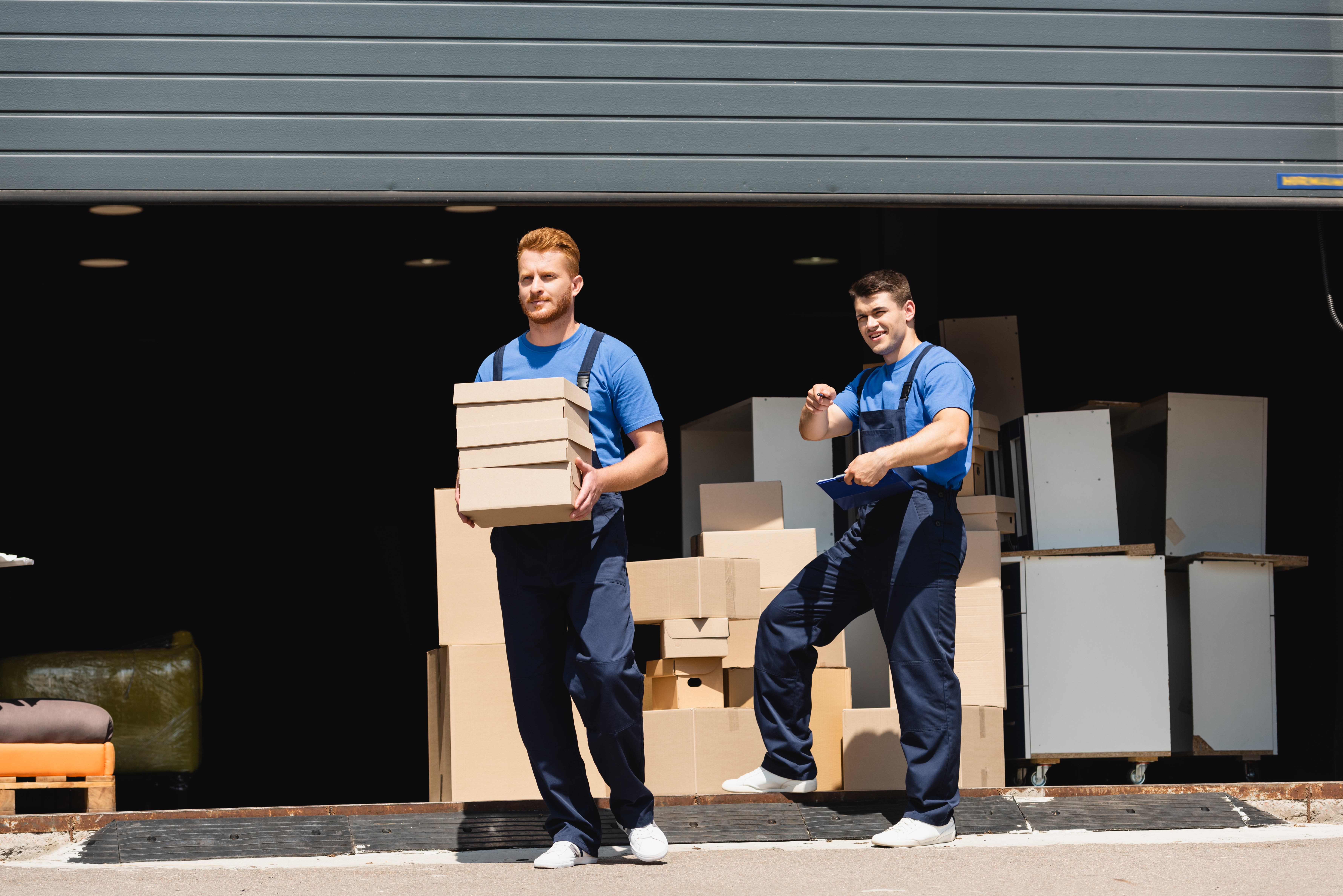 Mover with clipboard reviewing costs and boxes in St. Petersburg
